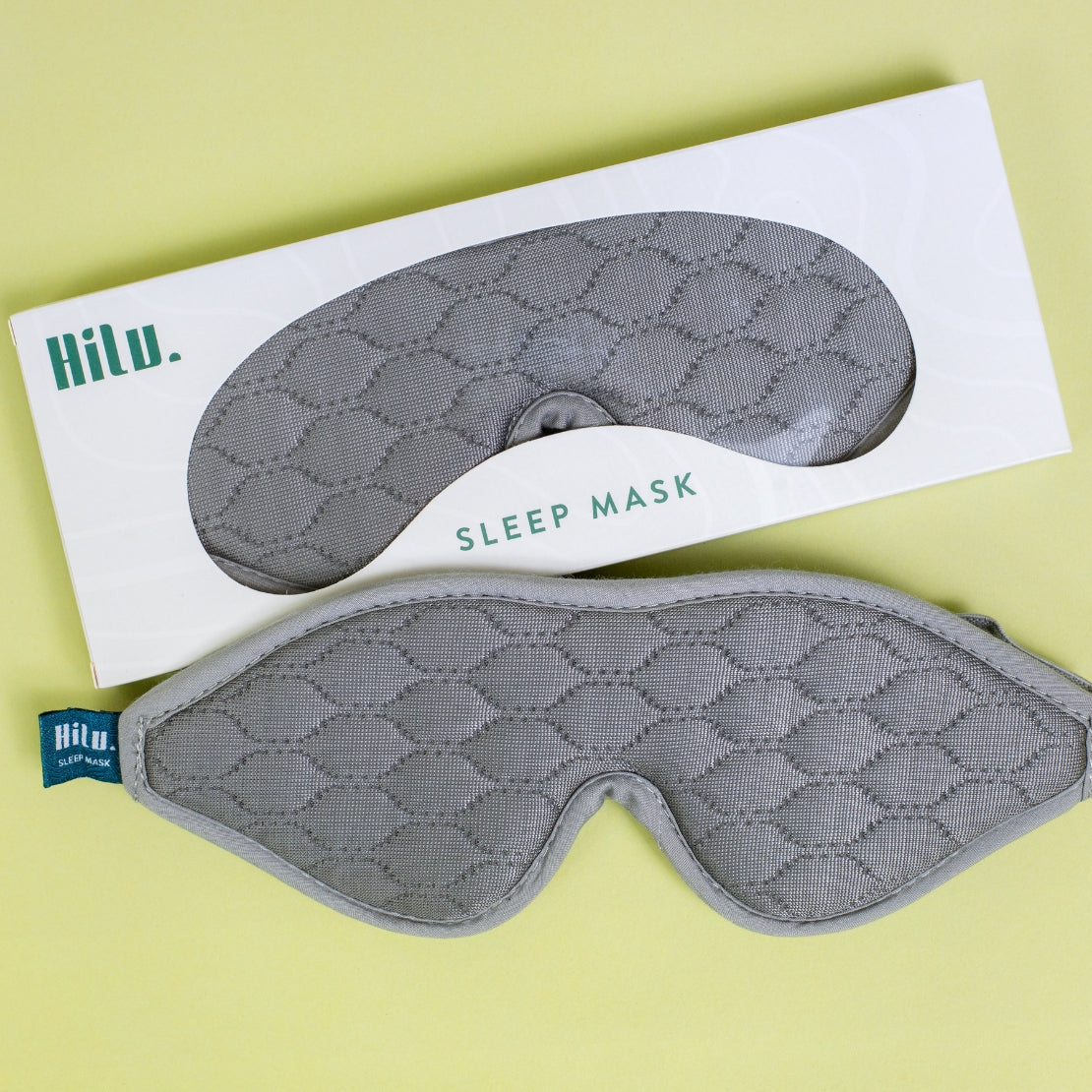 Grey textured sleeping mask with the brand name 'Hilu' displayed on the mask and its packaging